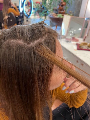 Profissional realizando a divisão precisa das mechas antes da aplicação da microfita